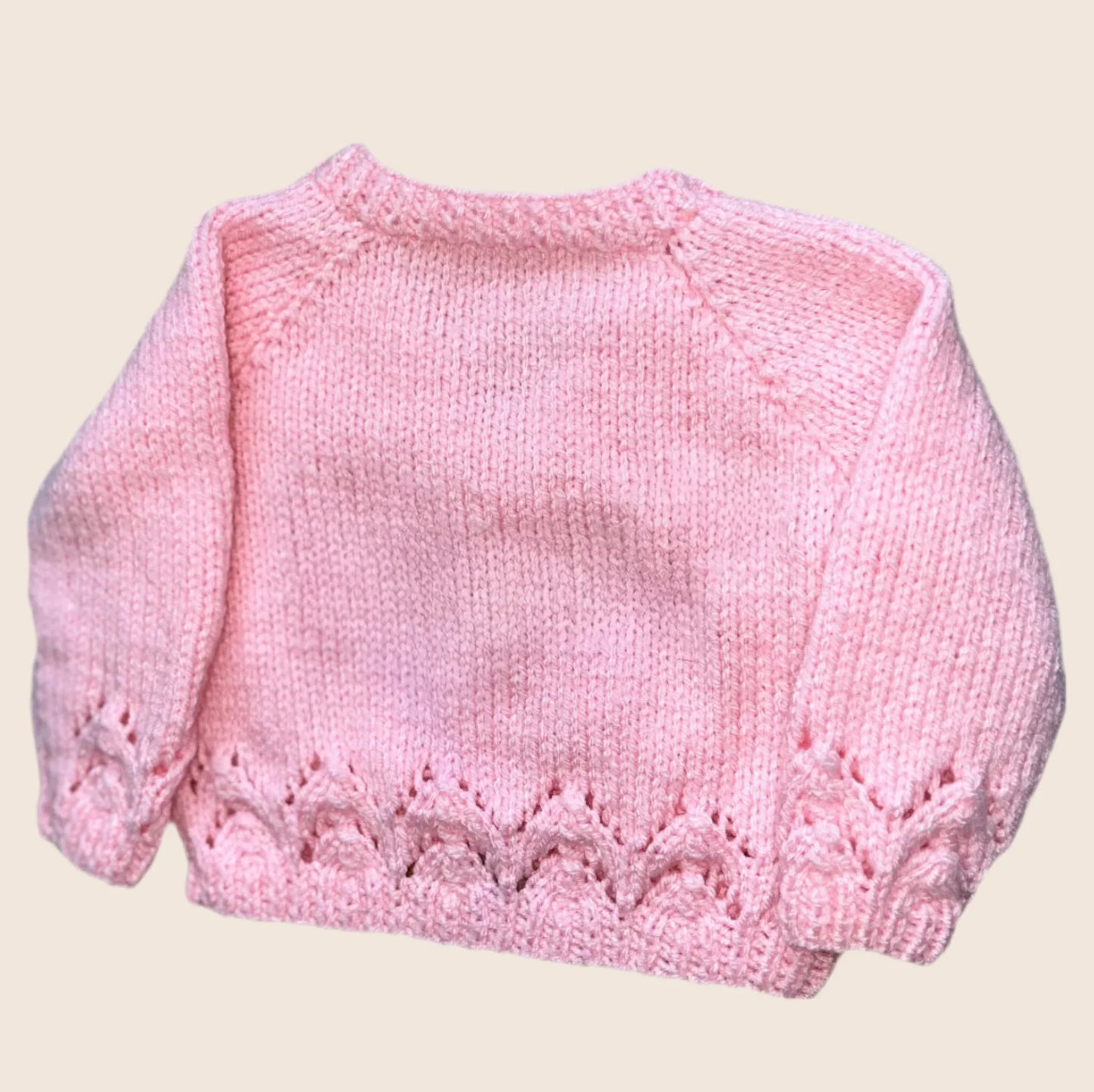 Soft pink knitted baby cardigan with decorative stitch pattern on cuffs and hem design a unique cardigan on our Knit Builder