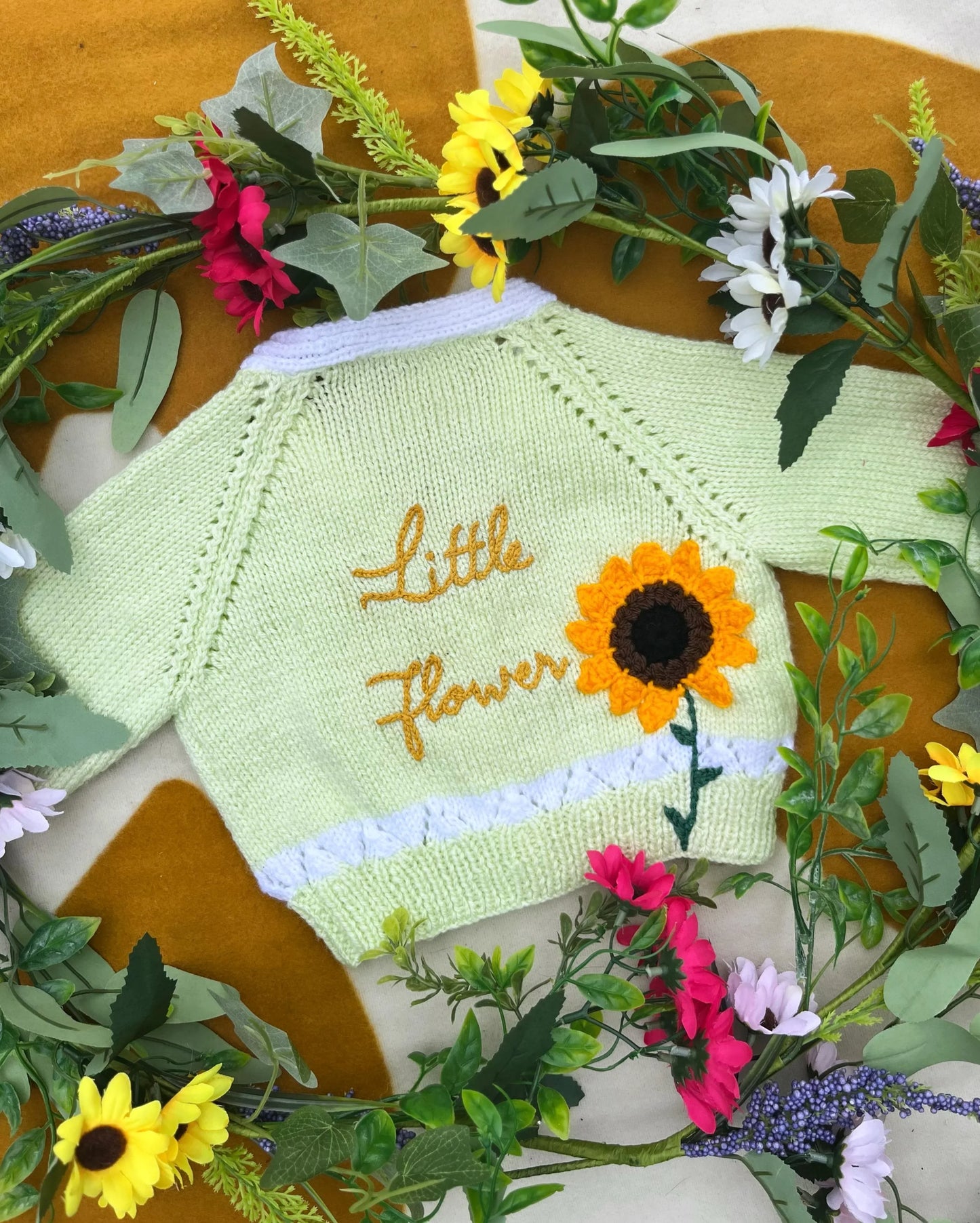 Little Flower Knits personalised sunflower cardigan for kids knitted in light green with embroidered sunflower and name