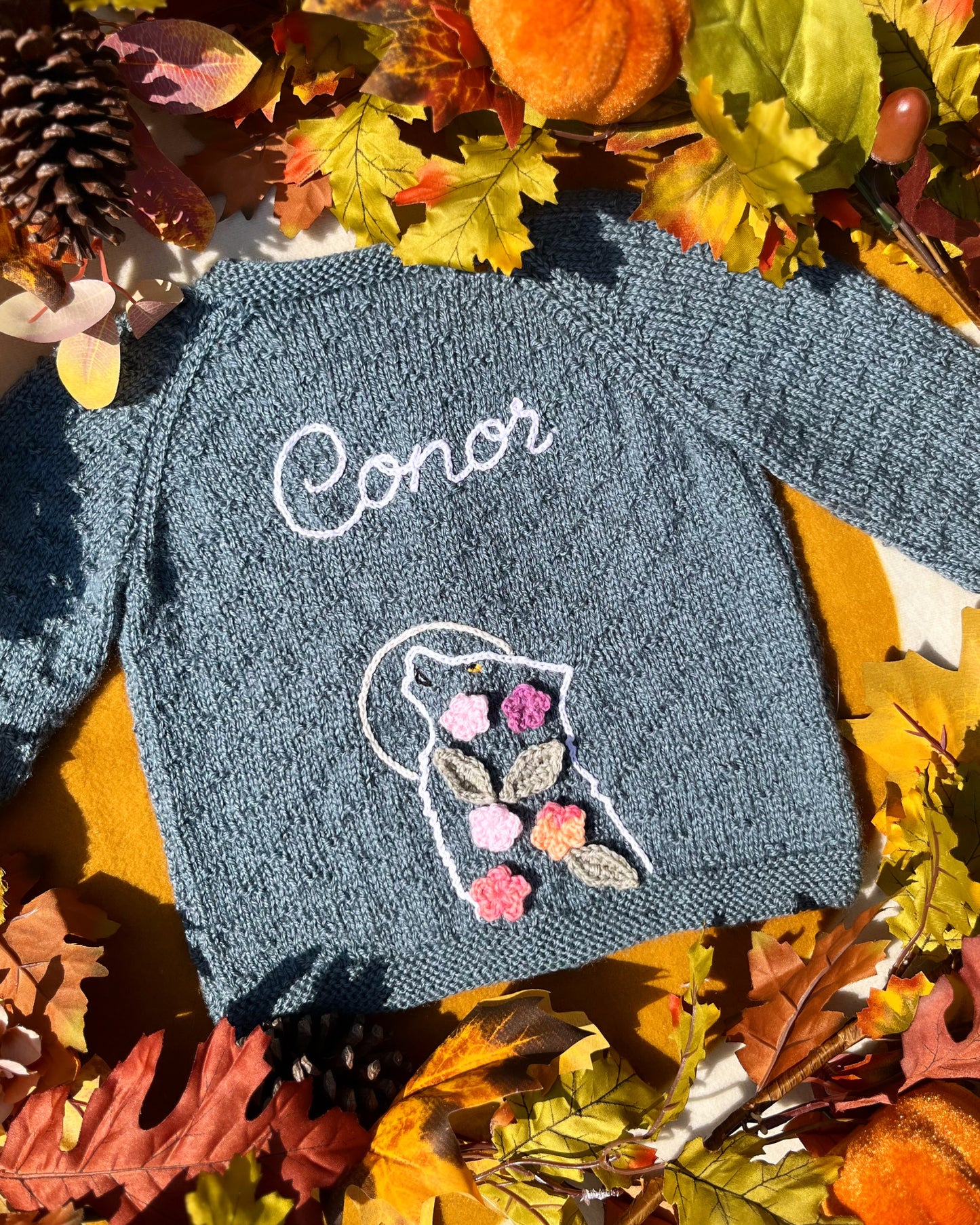 Little Flower Knits personalised blue knitted baby sweater named Conor with floral wolf motif unique boy wolf gift ideas