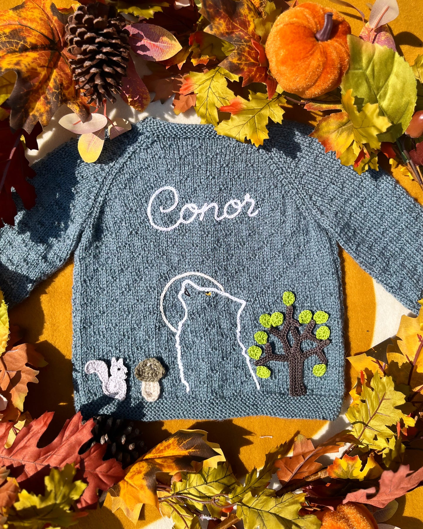 Hand knitted blue grey baby sweater named Conor with wolf outline squirrel tree appliques autumn leaves unique boy wolf gift ideas