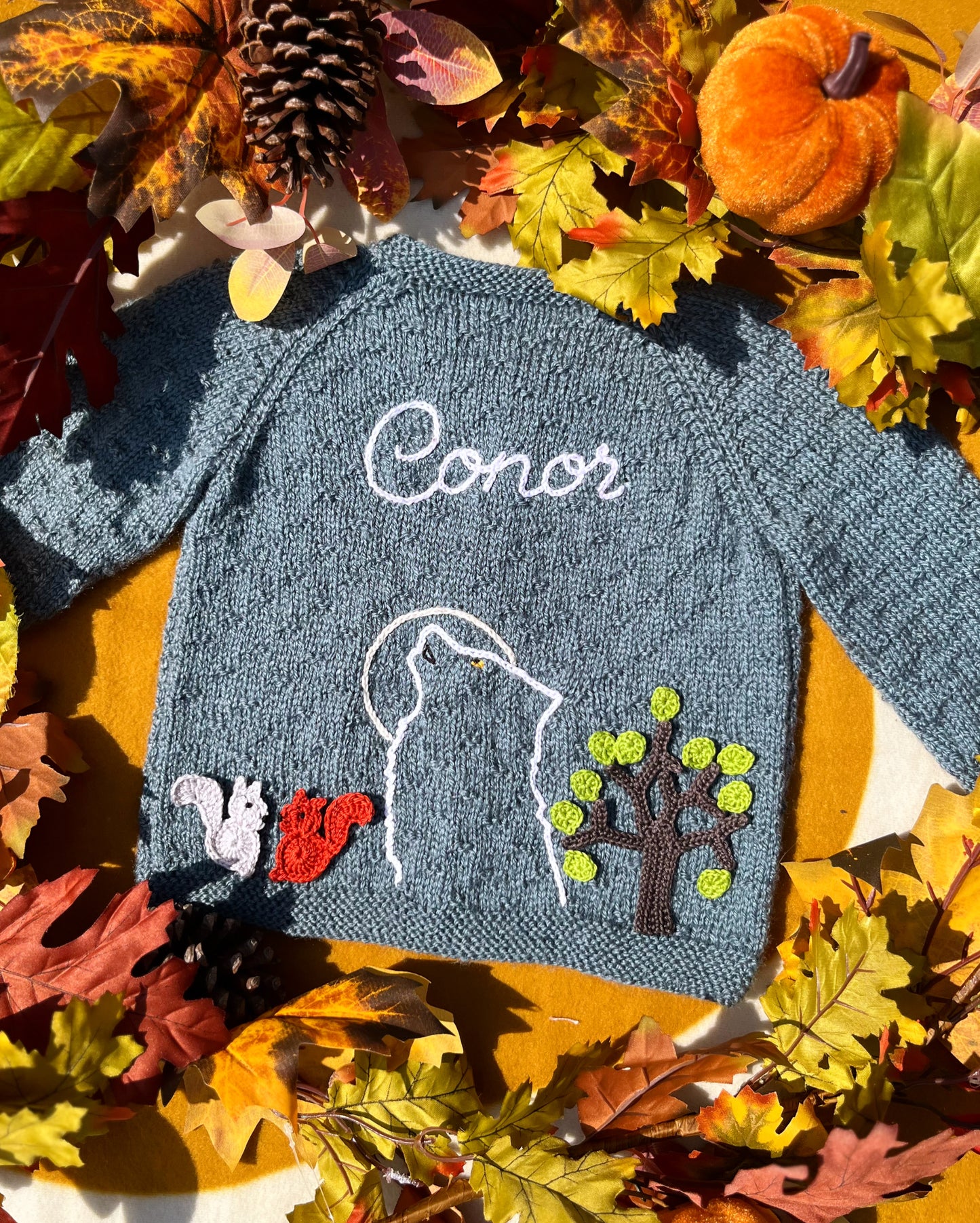 Personalised blue knitted childs cardigan with Conor howling wolf outline tree and squirrels unique boy wolf gift ideas