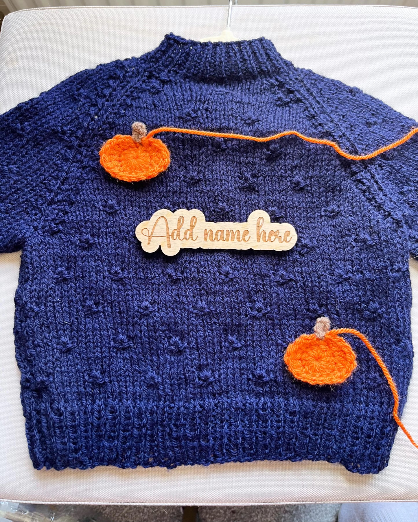 Navy handknit toddler jumper with two orange crocheted pumpkins and name tag custom pumpkin outfit for toddlers