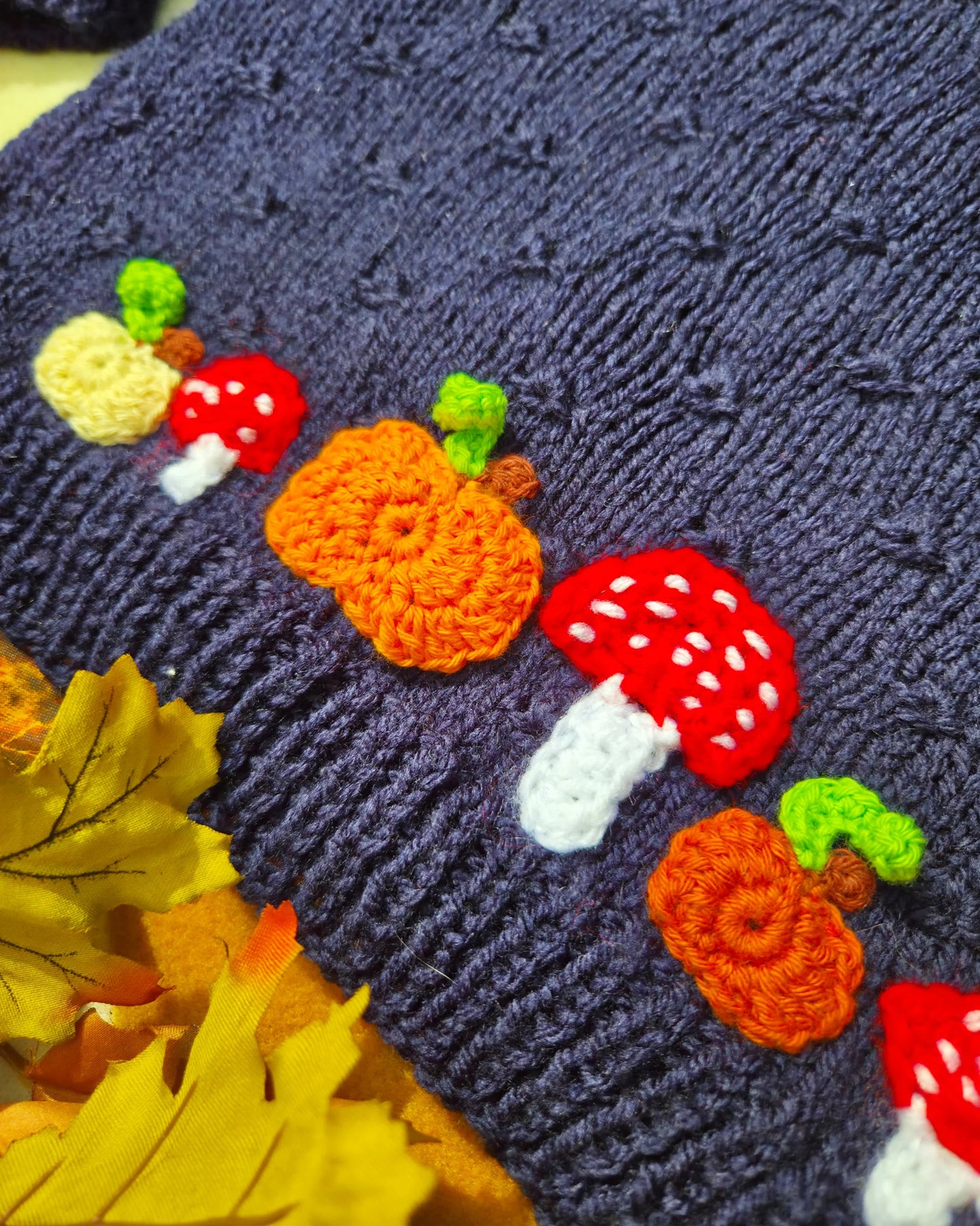 Little Flower Knits navy knitted fabric with crocheted pumpkins and red toadstools for hand-knitted pumpkin and toadstool costume