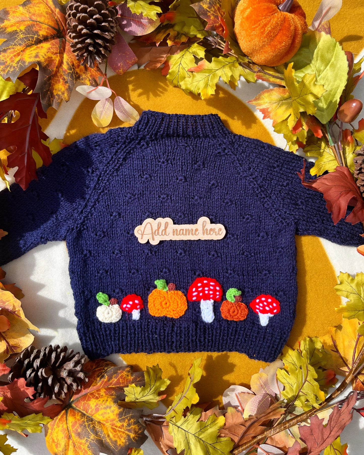 Little Flower Knits hand-knitted pumpkin and toadstool costume navy blue child sweater with name patch and autumn leaves