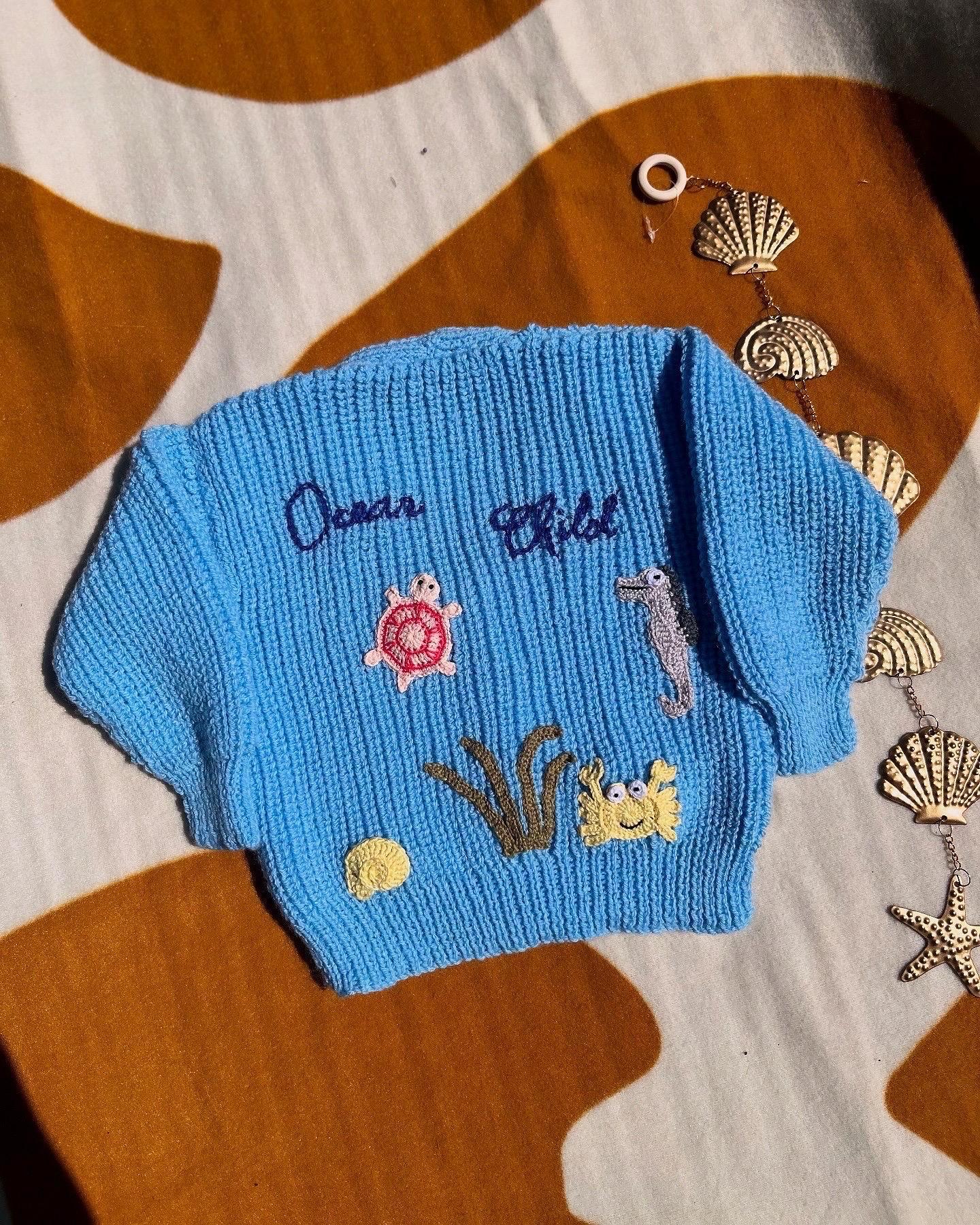 Handmade ocean theme baby knitwear UK blue sweater with embroidered sea creatures and initials by Little Flower Knits