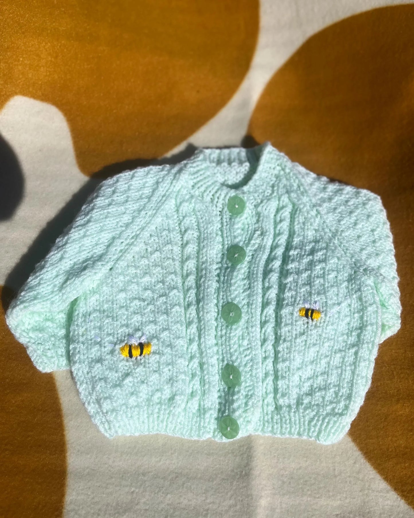 Lemon embroidery cardigan for babies by Little Flower Knits with green buttons and knitted bee details