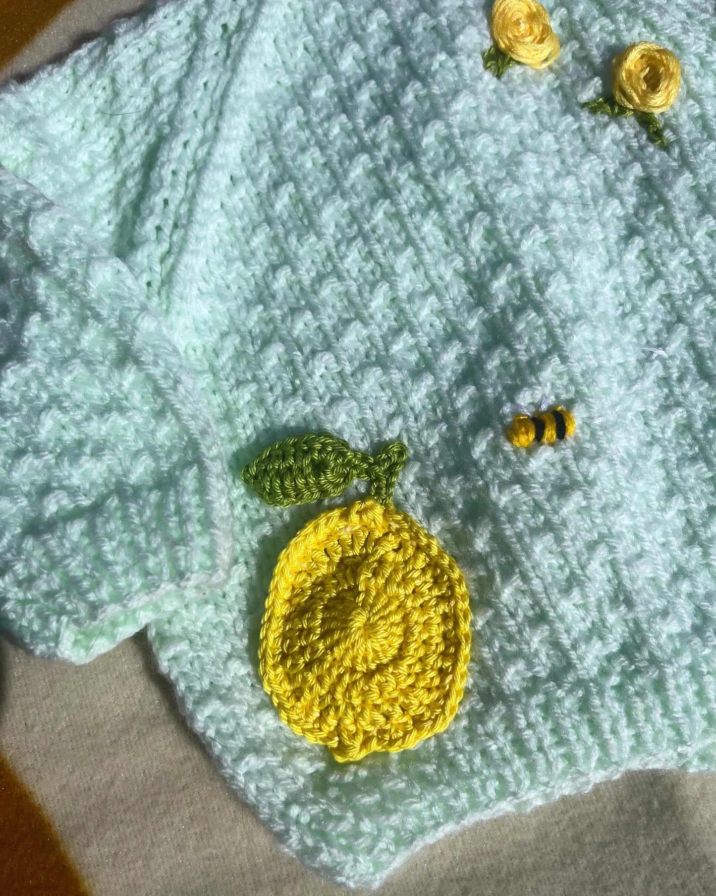 Lemon embroidery cardigan for babies with yellow crocheted lemon and small bee detail by Little Flower Knits