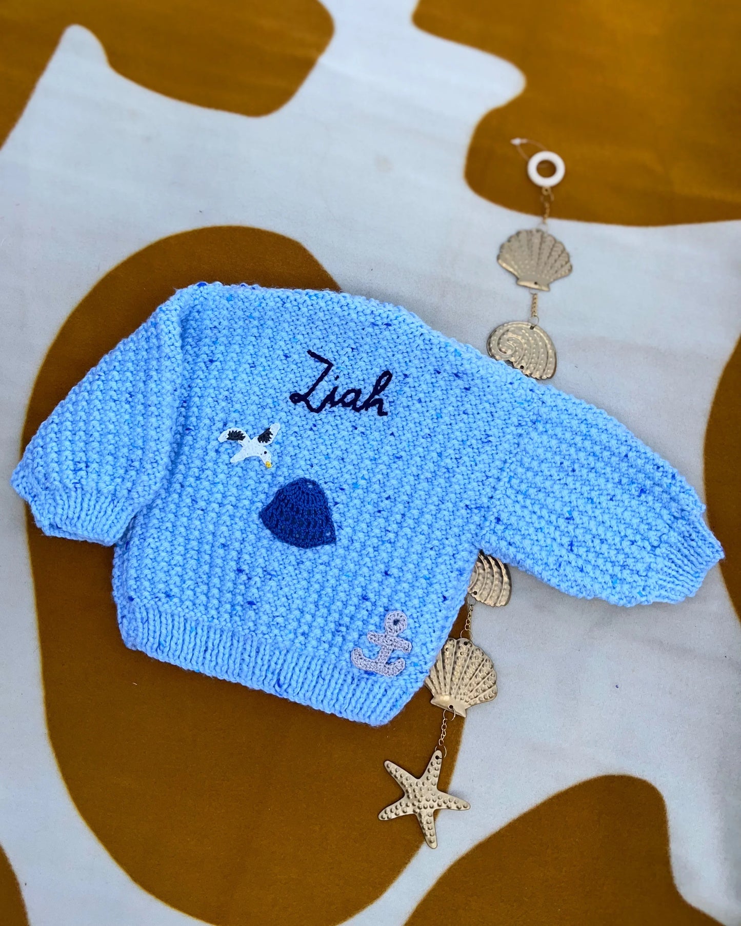 Blue personalised baby cardigan UK knitted with name and sea-themed buttons by Little Flower Knits