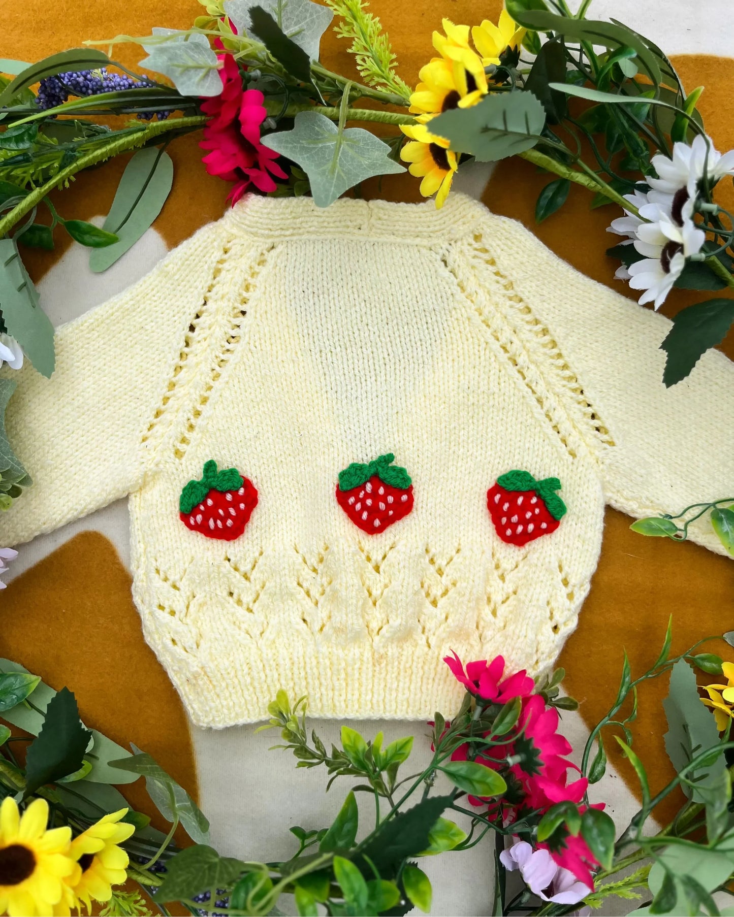 Personalised baby strawberry cardigan by Little Flower Knits in cream with three knitted strawberry decorations