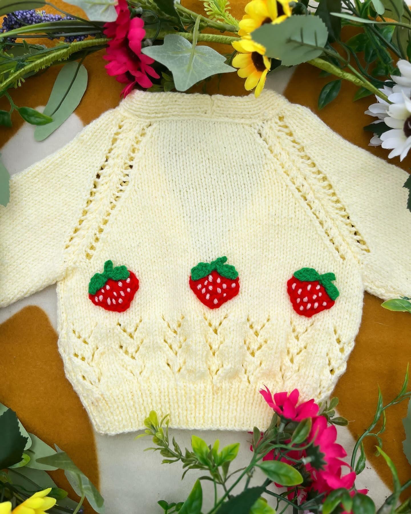 Cream knitted personalised baby strawberry cardigan with red strawberry appliques from Little Flower Knits