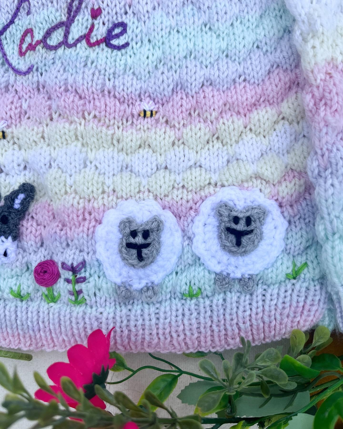 Close-up of personalised farm cardigan for toddlers with knitted sheep and embroidered name by Little Flower Knits