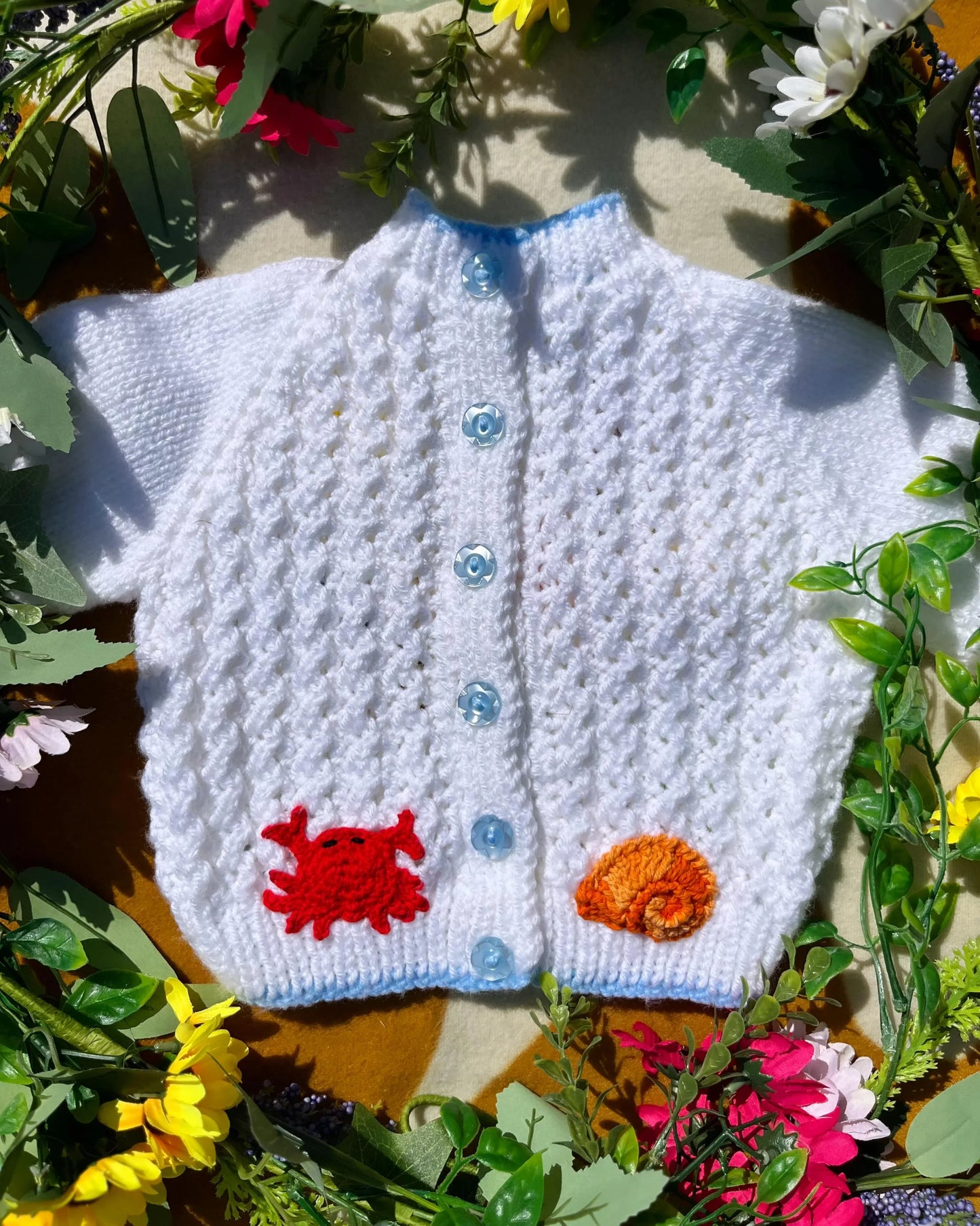 Little Flower Knits personalised mermaid cardigan in white with blue buttons and colourful sea creature patches