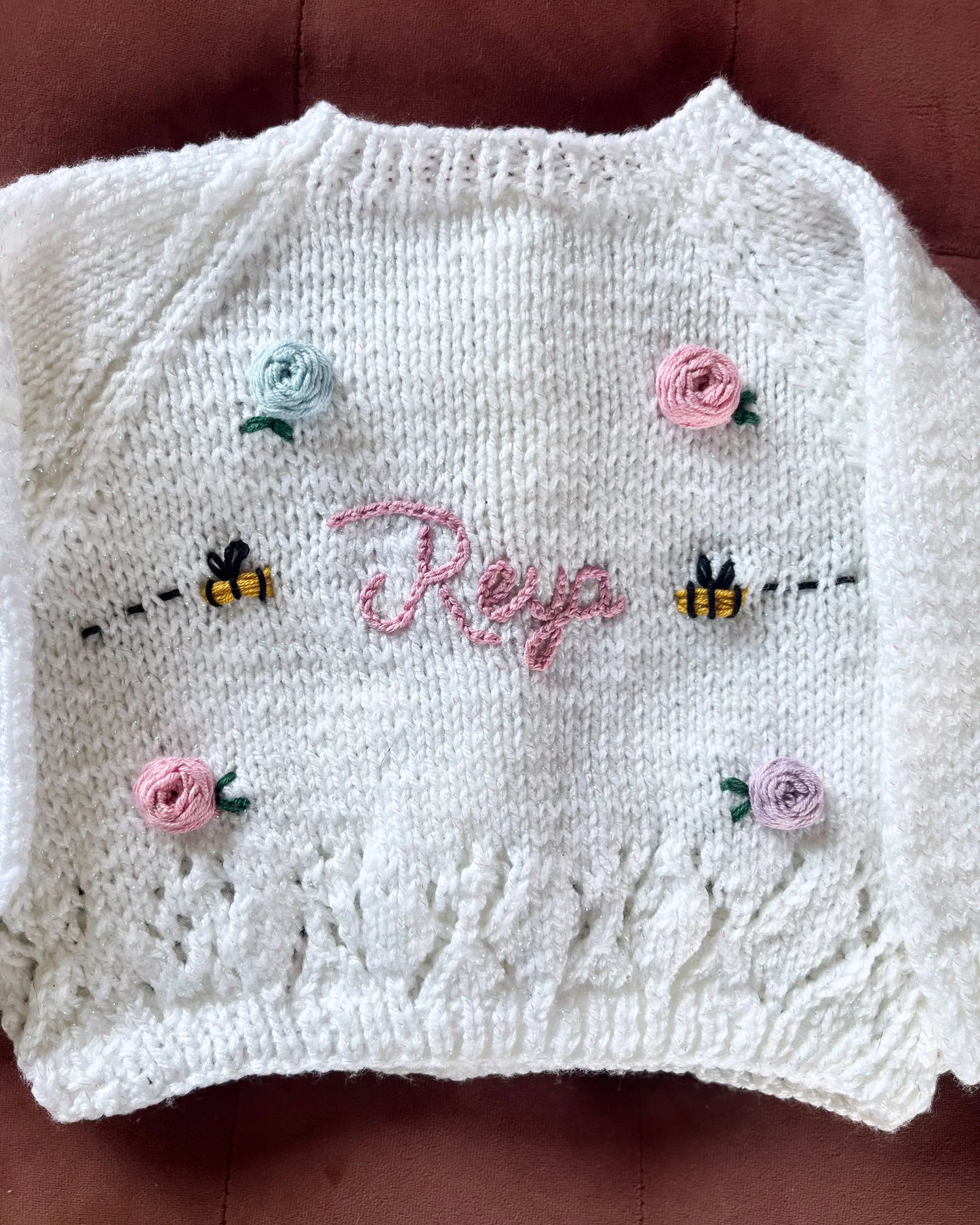 Personalised rose and bee cardigan knitted in white with embroidered name and floral buttons