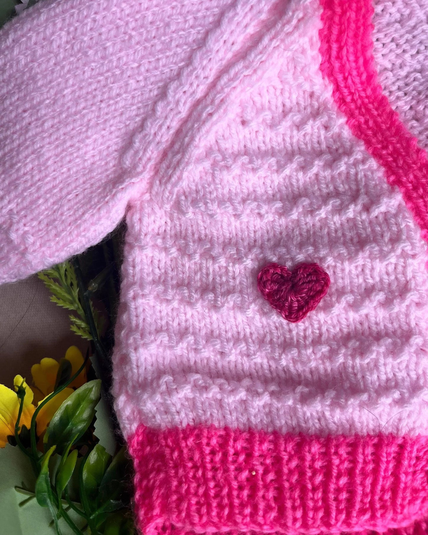 Pink knitted baby cardigan with dark pink heart button from Little Flower Knits unique baby fish cardigan