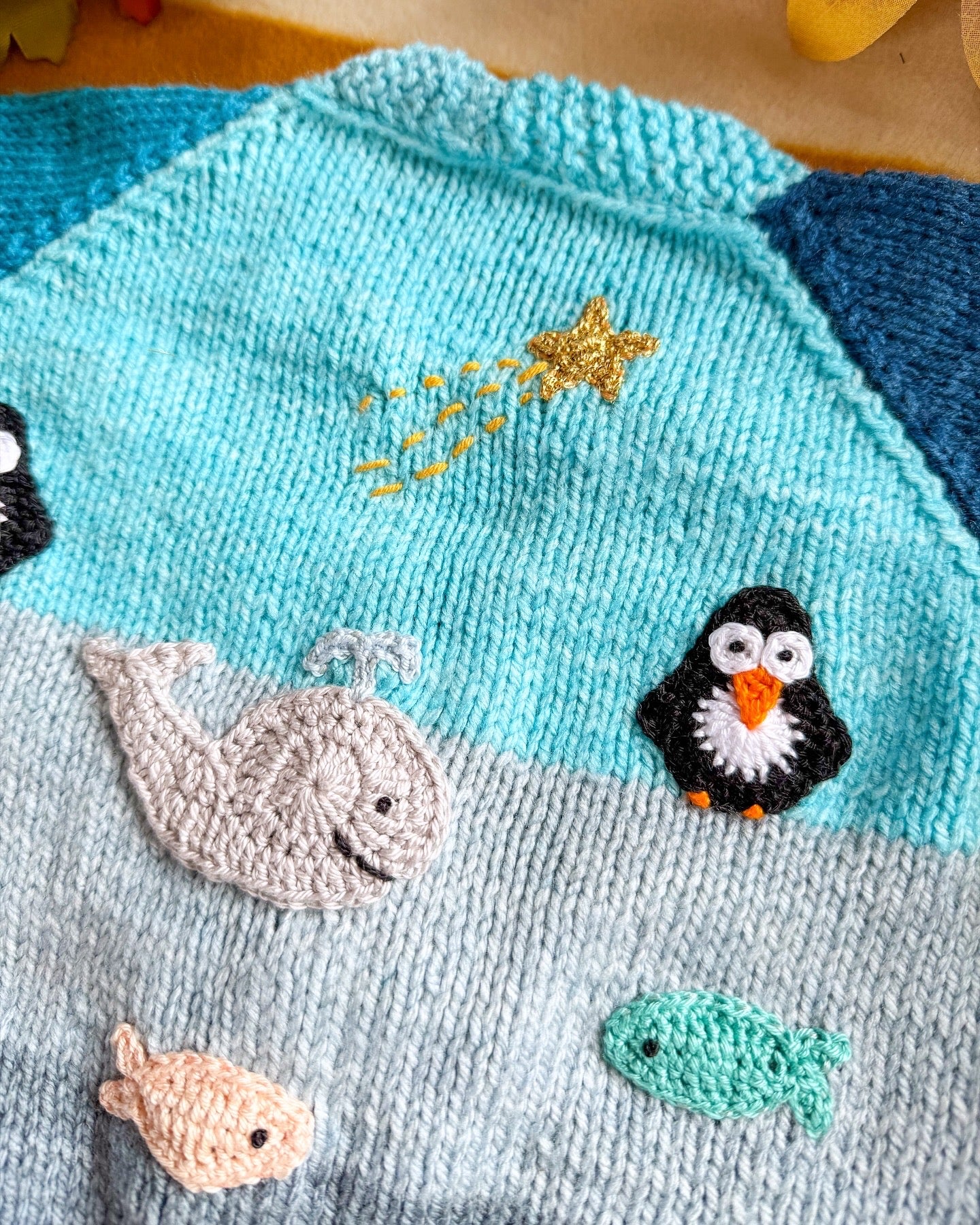 Little Flower Knits Arctic animals baby cardigan featuring embroidered sea creatures and vibrant colours