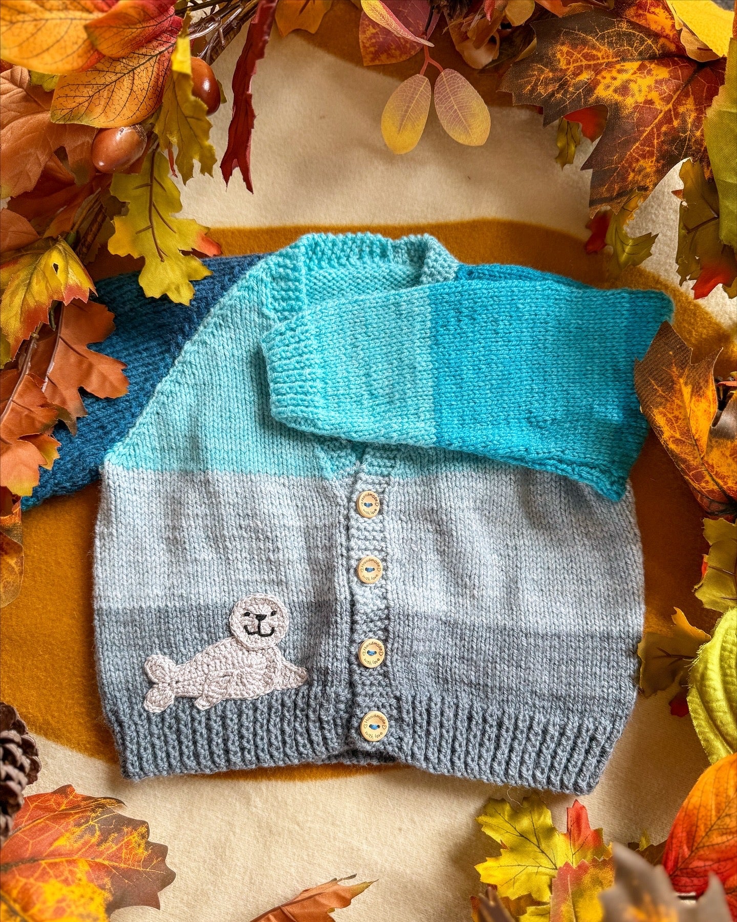 Little Flower Knits Arctic animals baby cardigan in grey and blue with a seal patch and wooden buttons