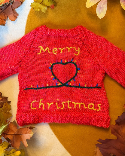 Handknitted Christmas baby cardigan 3-6 months with festive 'Merry Christmas' design and colourful lights