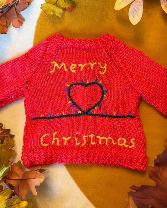 Handknitted Christmas baby cardigan 3-6 months with festive 'Merry Christmas' design and colourful lights