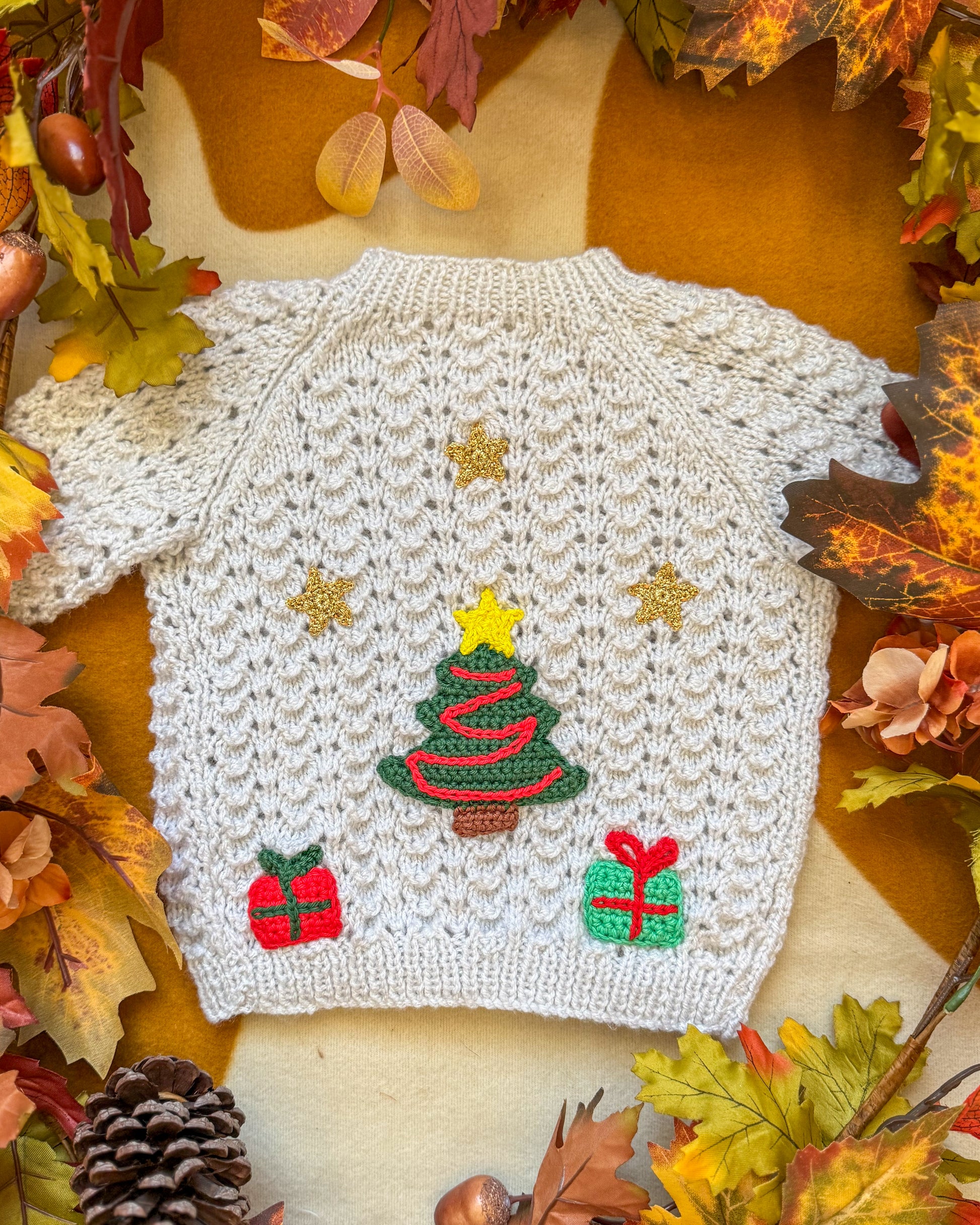 Hand-knit Christmas tree cardigan baby in cream with festive tree and gift patterns
