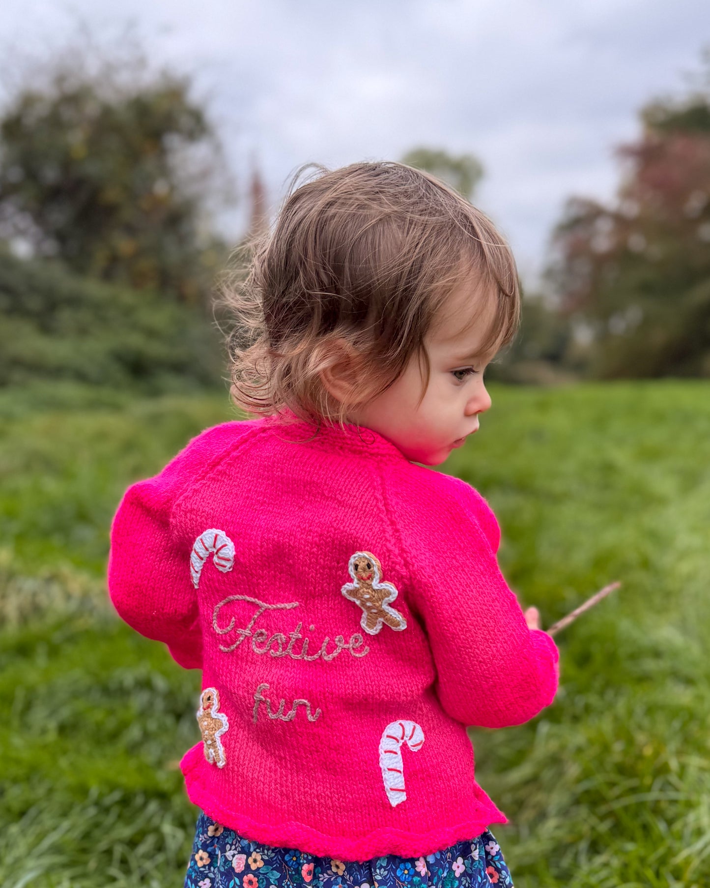 Bright pink festive personalised kids cardigan with gingerbread and candy cane decorations