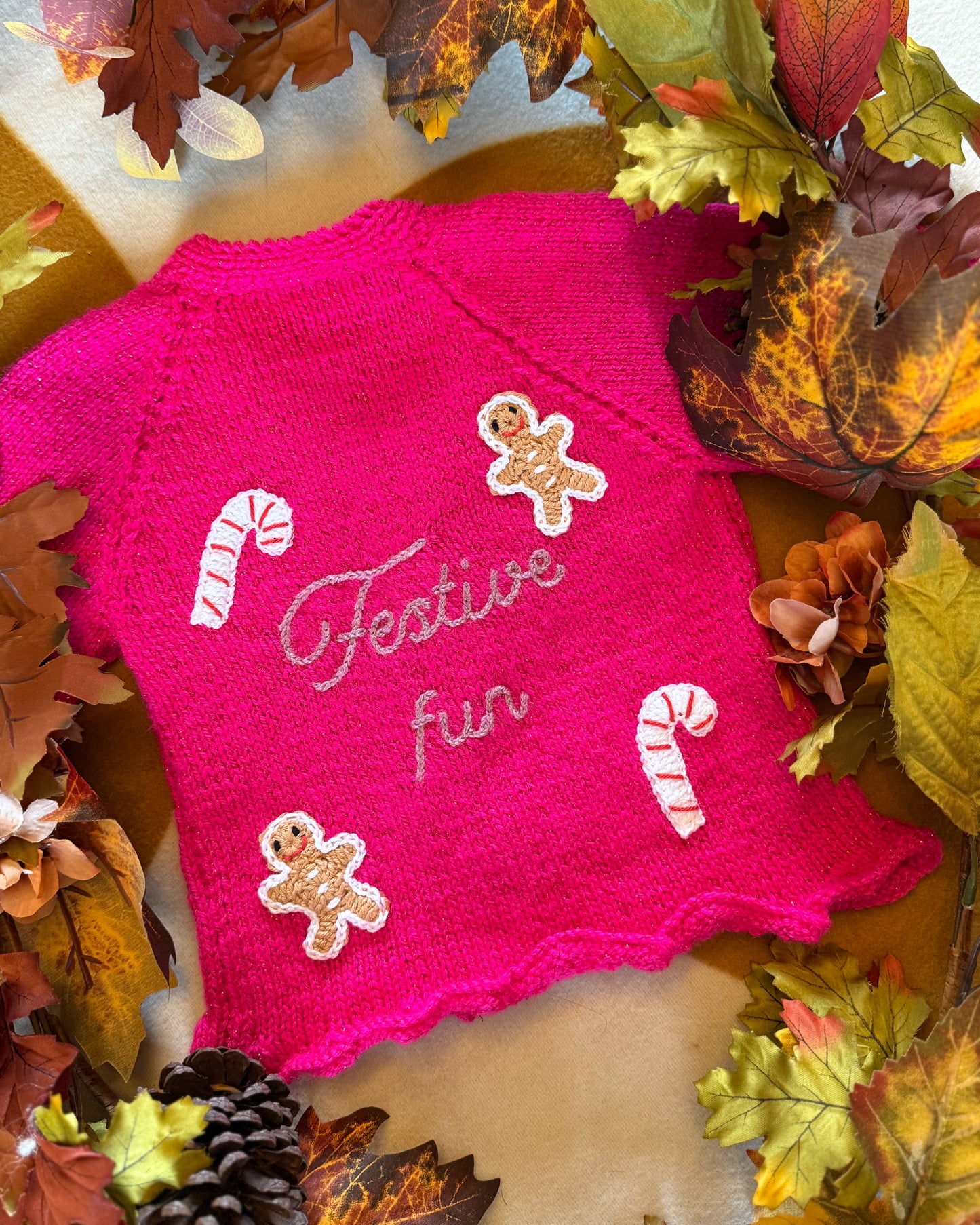 Festive personalised kids cardigan in bright pink with gingerbread and candy cane decorations