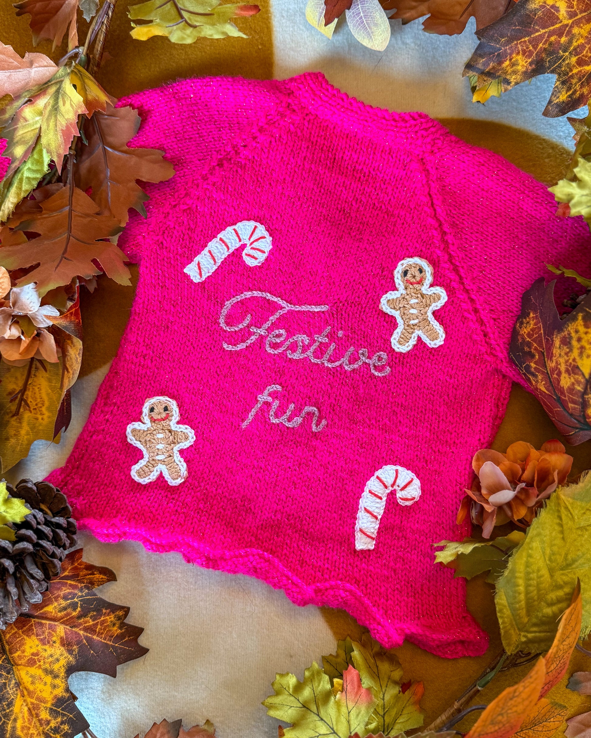 Festive personalised kids cardigan in bright pink with gingerbread men and candy canes design