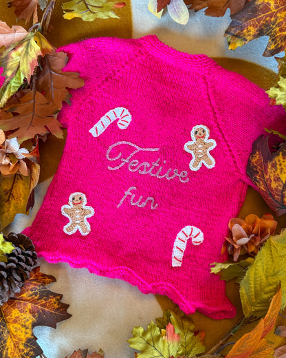 Festive personalised kids cardigan in bright pink with gingerbread men and candy canes design