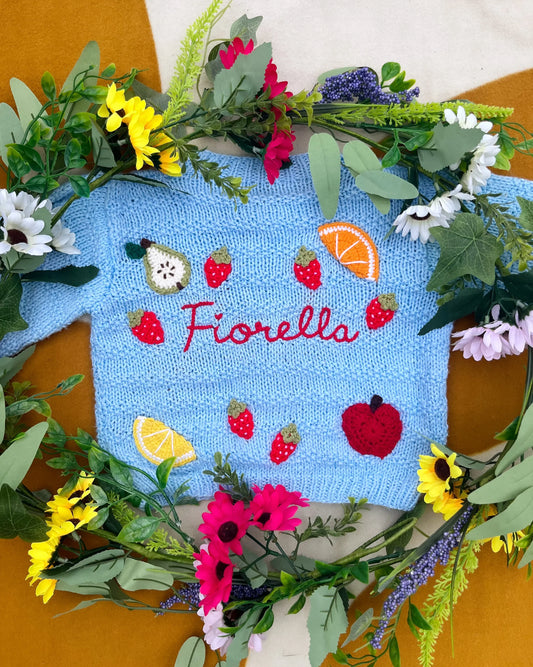 Little Flower Knits blue fruit pattern cardigan for toddlers with embroidered name Fiorella surrounded by flowers