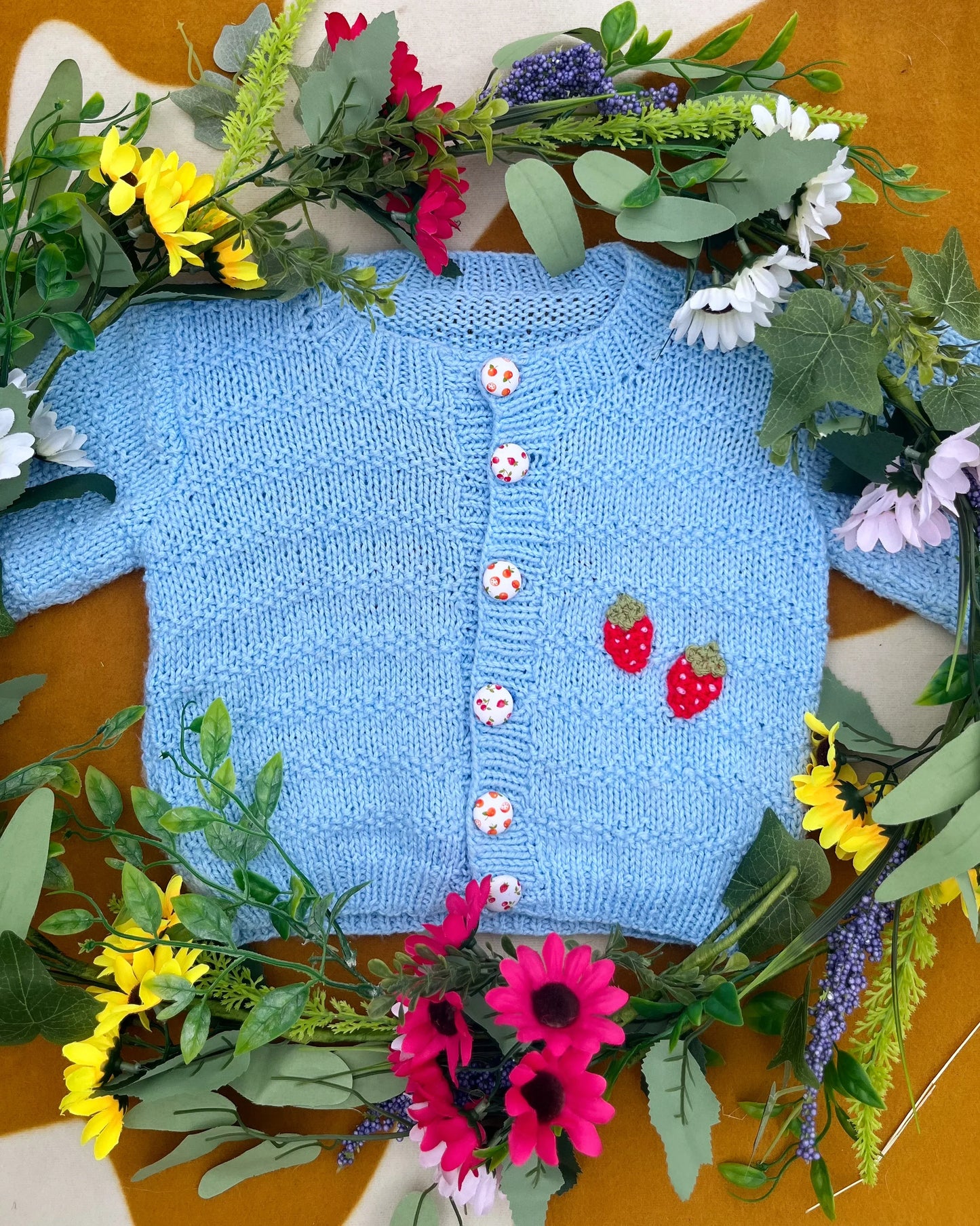 Little Flower Knits blue fruit pattern cardigan for toddlers with strawberry motifs and decorative buttons