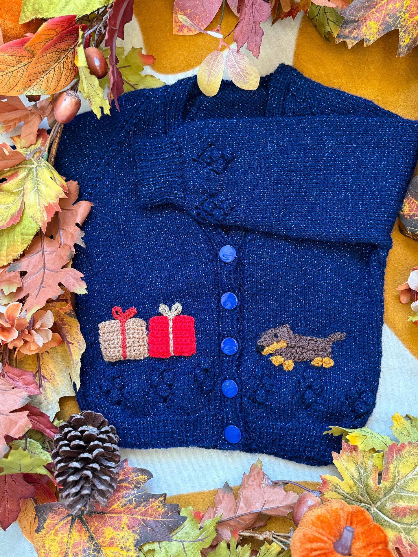 Navy blue knitted Grinchmas cardigan for toddlers with festive gift embellishments