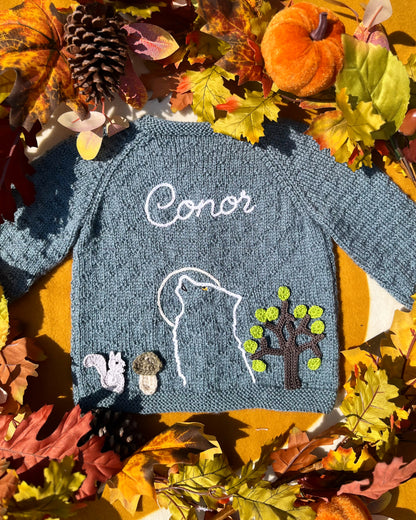Hand knitted blue grey baby sweater named Conor with wolf outline squirrel tree appliques autumn leaves unique boy wolf gift ideas