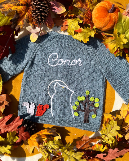 Personalised blue knitted childs cardigan with Conor howling wolf outline tree and squirrels unique boy wolf gift ideas