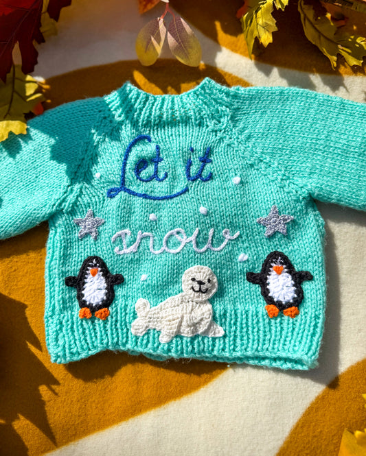Handmade baby cardigan UK featuring cute penguins and a snowman design with the text Let it snow