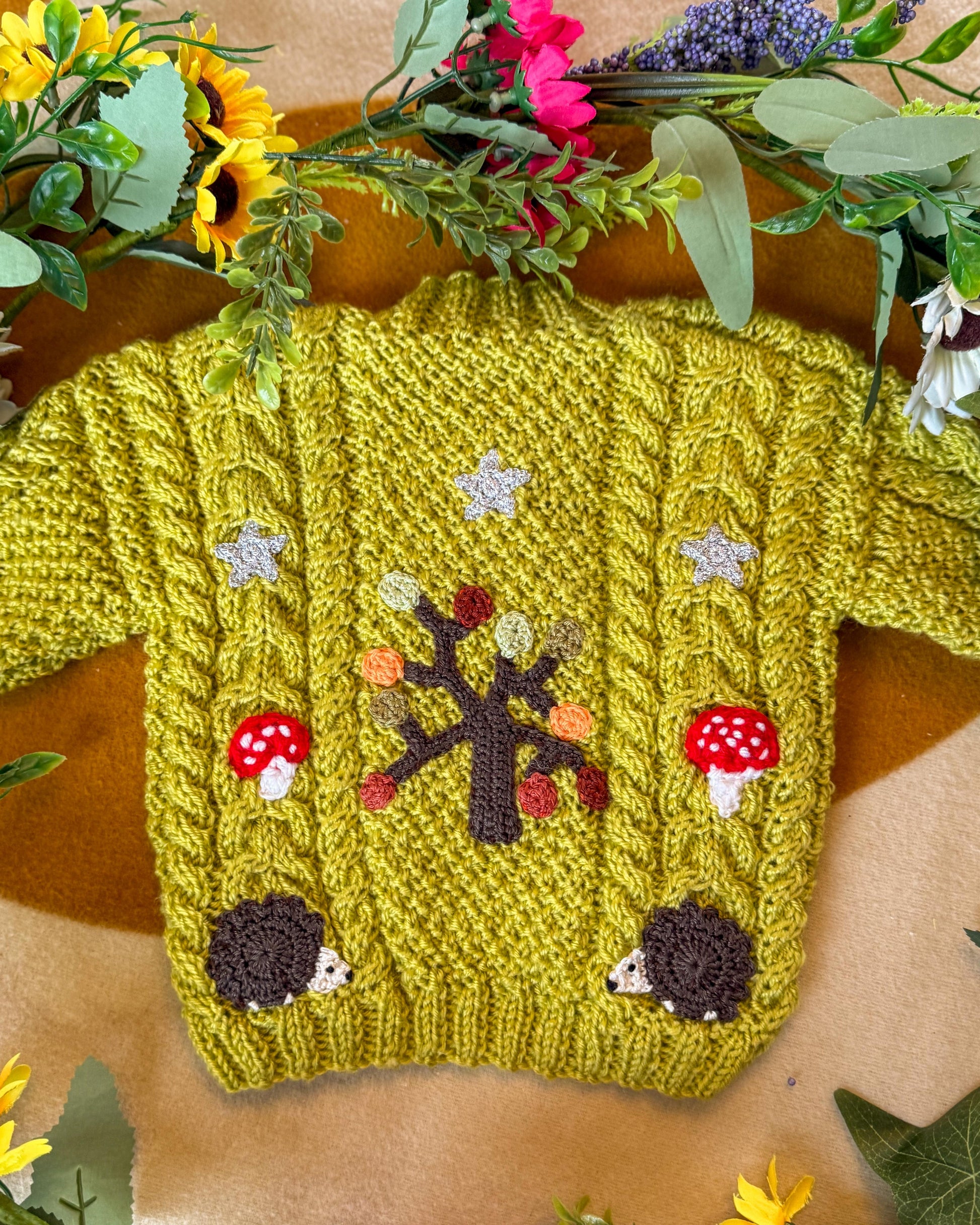 Handmade baby cardigan UK in vibrant green with whimsical tree and hedgehog designs