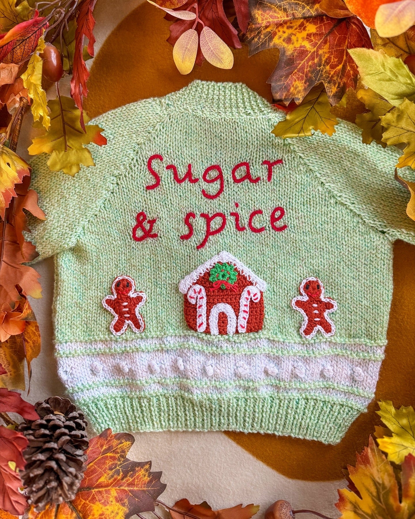 Handmade baby cardigan UK with 'Sugar & Spice' embroidery and gingerbread house design