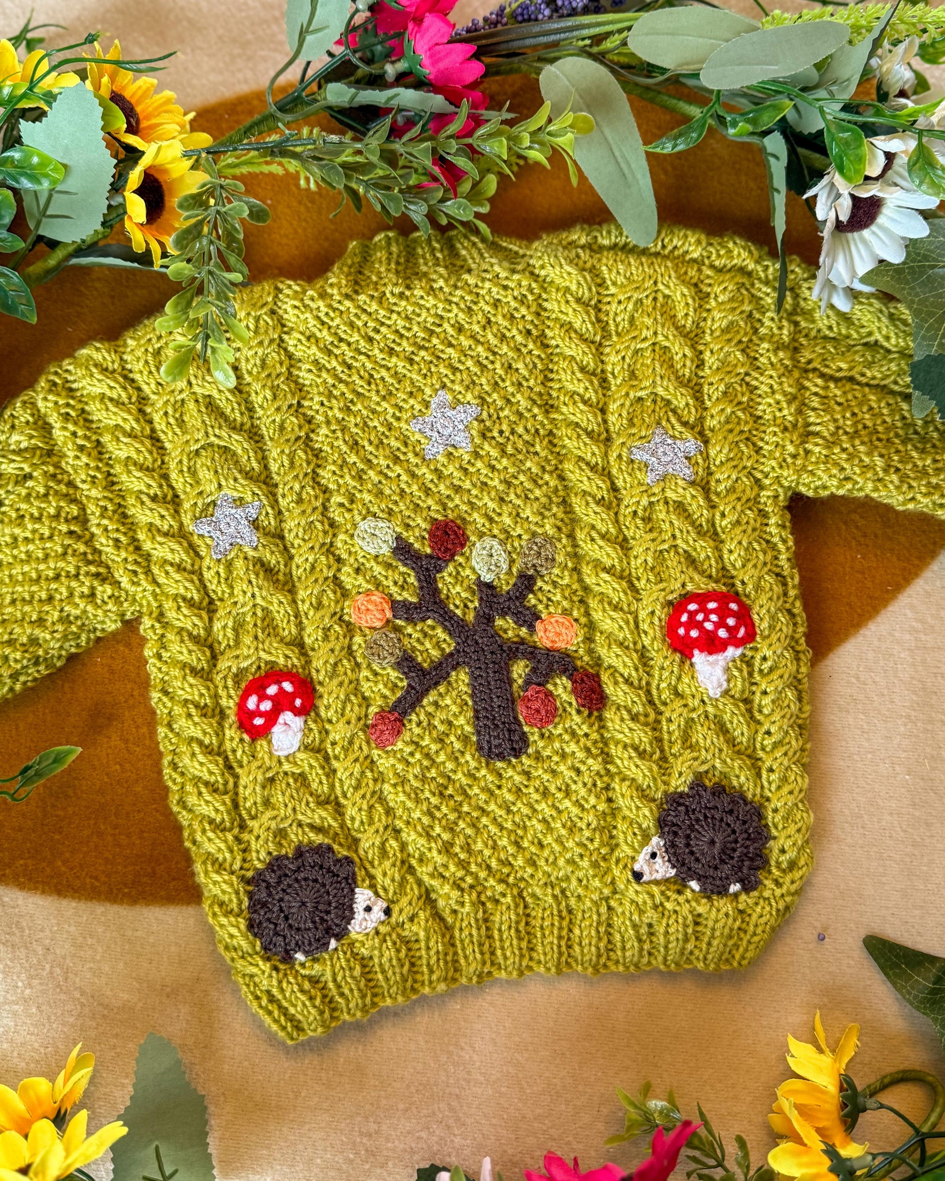 Handmade baby cardigan UK in bright green with hedgehog and mushroom designs