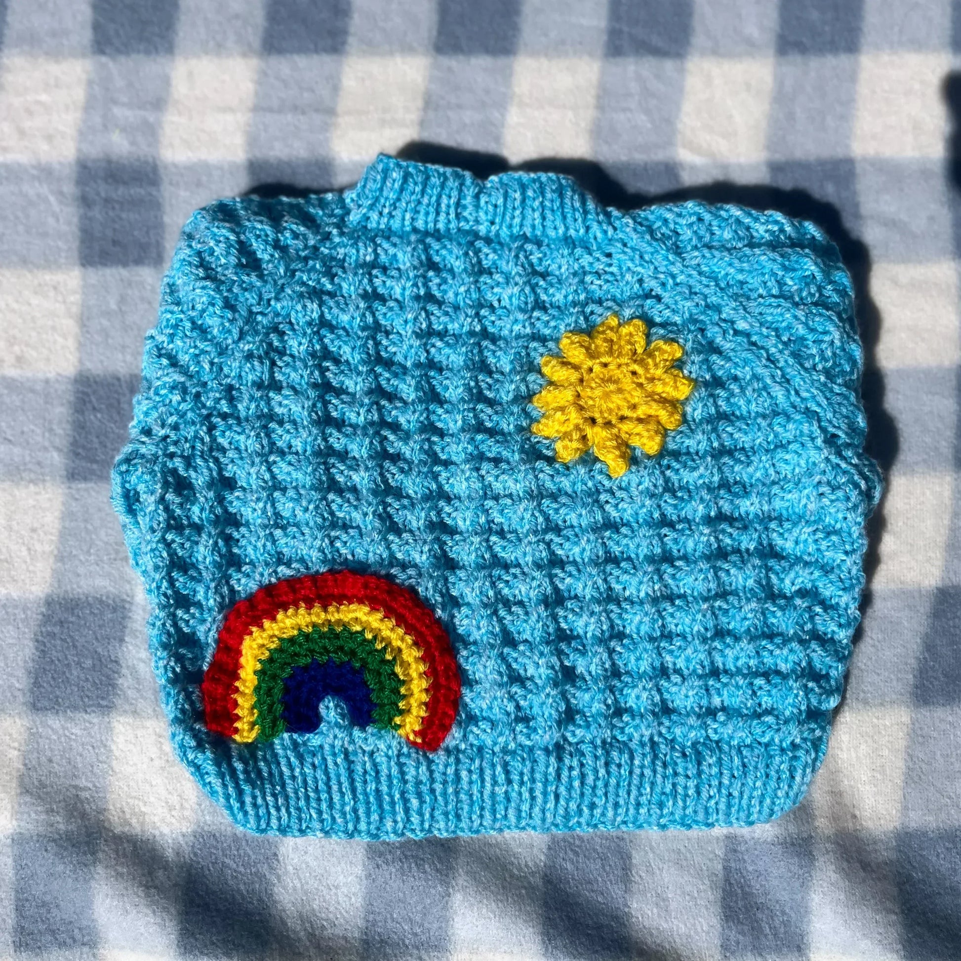 Blue newborn cardigan with rainbow and yellow sun knitted by Little Flower Knits