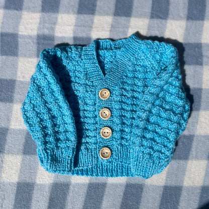 Blue newborn cardigan with rainbow textured knit and four wooden buttons by Little Flower Knits