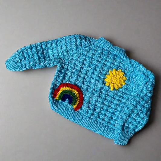 Blue newborn cardigan with rainbow and yellow flower knitted by Little Flower Knits