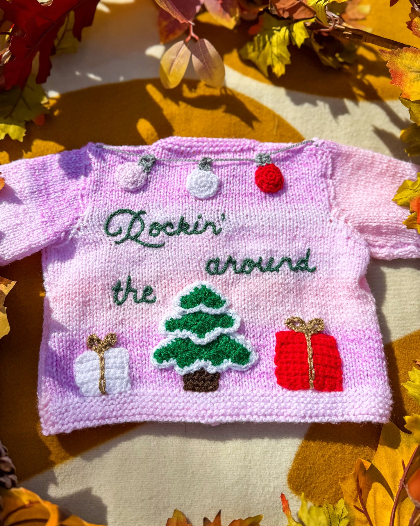 Handmade Christmas cardigan baby in pink with festive decorations and embroidered text