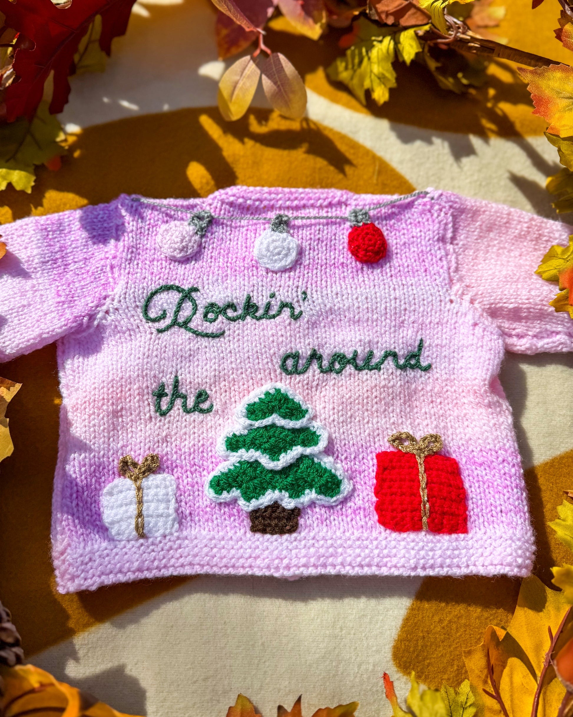 Handmade Christmas cardigan baby in pink with festive decorations and embroidered text