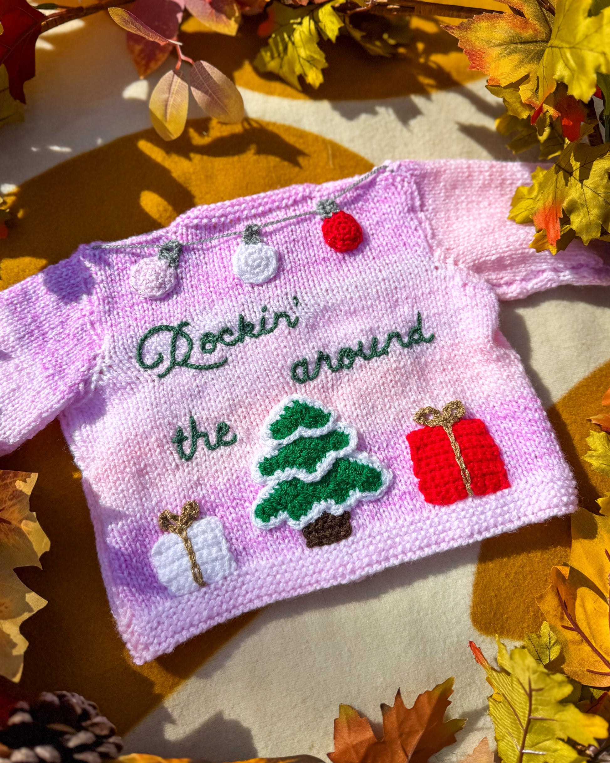 Handmade Christmas cardigan baby in pink with festive tree and gift decorations