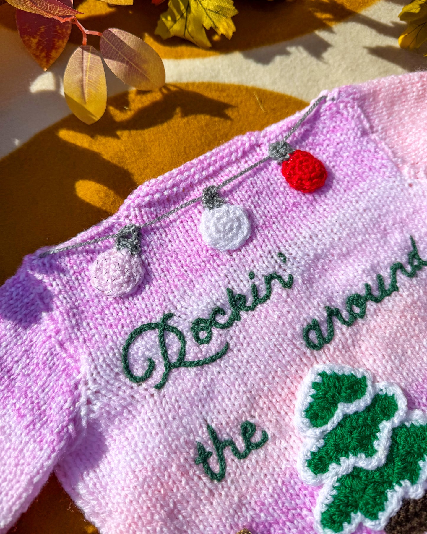 Handmade Christmas cardigan baby featuring festive decorations and vibrant colours for the holiday season