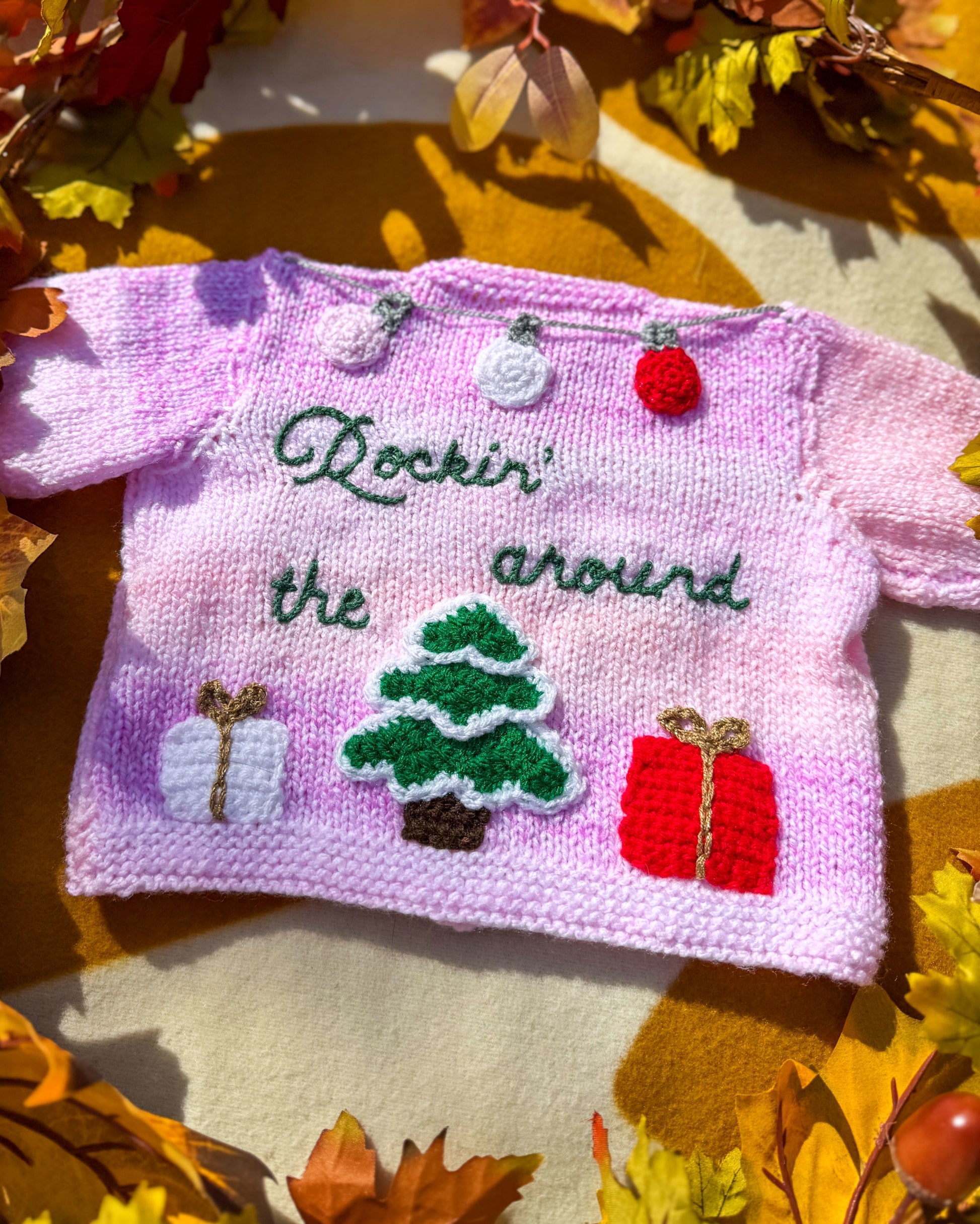 Handmade Christmas cardigan baby featuring festive designs like a Christmas tree and gifts