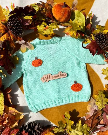 Mint green knitted toddler sweater with orange pumpkin appliques and wooden name tag custom pumpkin outfit for toddlers