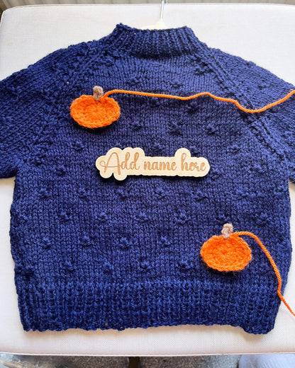 Navy handknit toddler jumper with two orange crocheted pumpkins and name tag custom pumpkin outfit for toddlers
