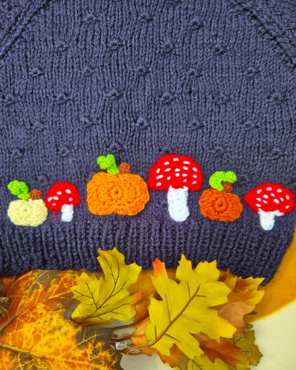 Little Flower Knits dark blue jumper hem with autumn appliques featuring hand-knitted pumpkin and toadstool costume motifs