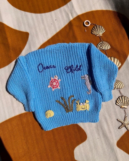 Handmade ocean theme baby knitwear UK blue sweater with embroidered sea creatures and initials by Little Flower Knits