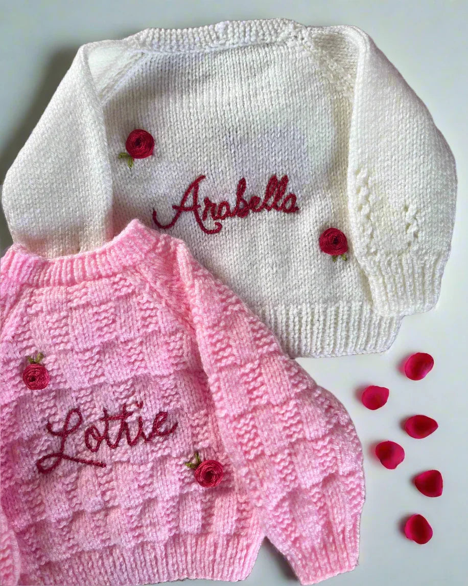 Personalised rose baby cardigan in white and pink with embroidered names and decorative rose buttons