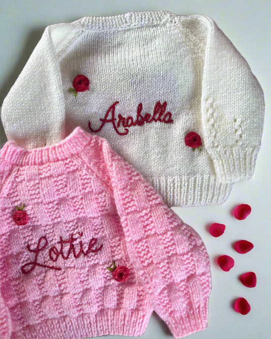 Personalised rose baby cardigan in white and pink with embroidered names and decorative rose buttons